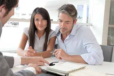 Couple discussing finances at table, accessing home equity through cash-out refinance loans in New York and Pennsylvania