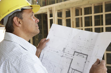 Construction worker reviewing renovation plans, perfect for FHA 203k home improvement loans in NY & PA